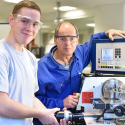Azubi und Ausbilder an einer Drehmaschine in der Berufsausblidung